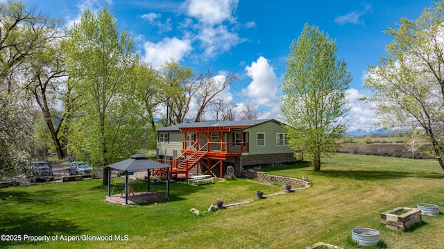 back of property featuring a yard, a gazebo, and stairway