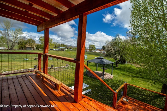 wooden deck featuring a yard and a gazebo
