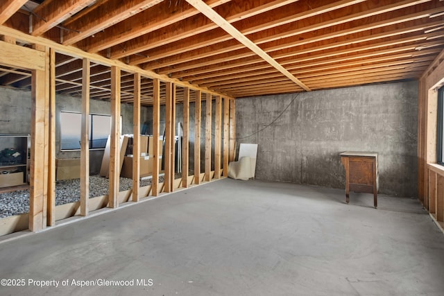 miscellaneous room with unfinished concrete flooring