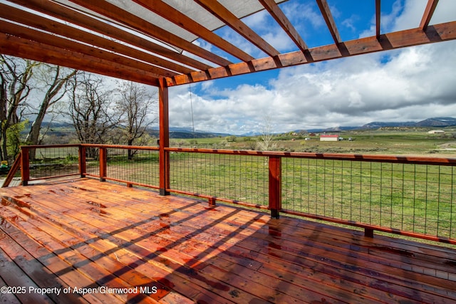 wooden deck with a pergola and a rural view