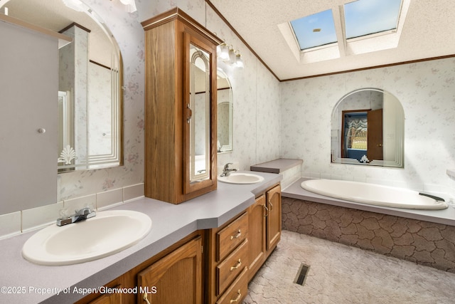 full bath with a sink, a skylight, a garden tub, and wallpapered walls