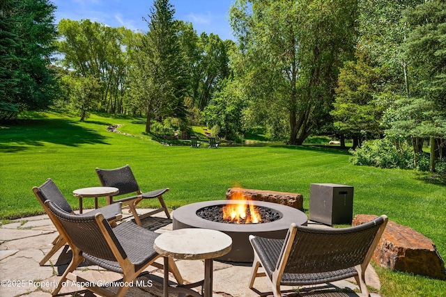2755 Lower River Rd, Snowmass, CO 81654 - view of patio / terrace with an outdoor fire pit and view of wooded area