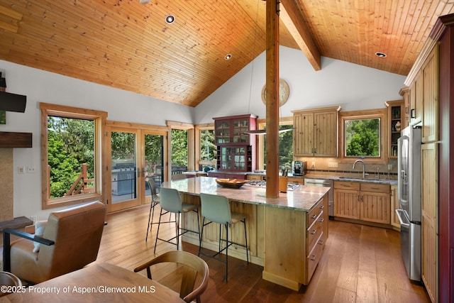2755 Lower River Rd, Snowmass, CO 81654 - kitchen with stainless steel appliances, a kitchen island, light stone countertops, hardwood / wood-style flooring, and high vaulted ceiling