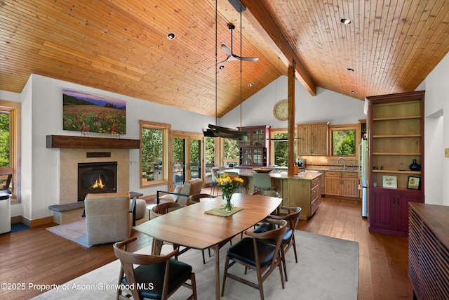 2755 Lower River Rd, Snowmass, CO 81654 - dining room featuring a glass covered fireplace, light wood-style flooring, high vaulted ceiling, and a wooden ceiling with exposed beams