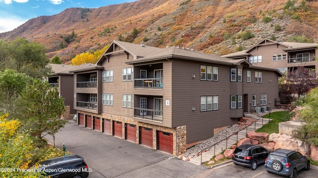 view of property with central AC unit, a mountain view, and a garage