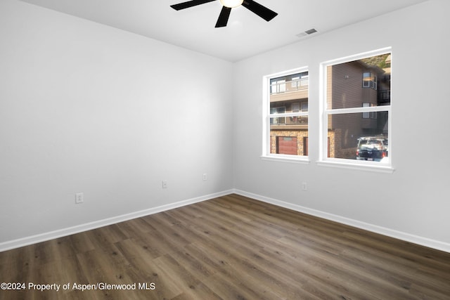 unfurnished room with ceiling fan and dark hardwood / wood-style flooring