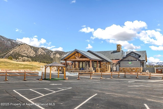 view of car parking with a gazebo, a mountain view, and fence