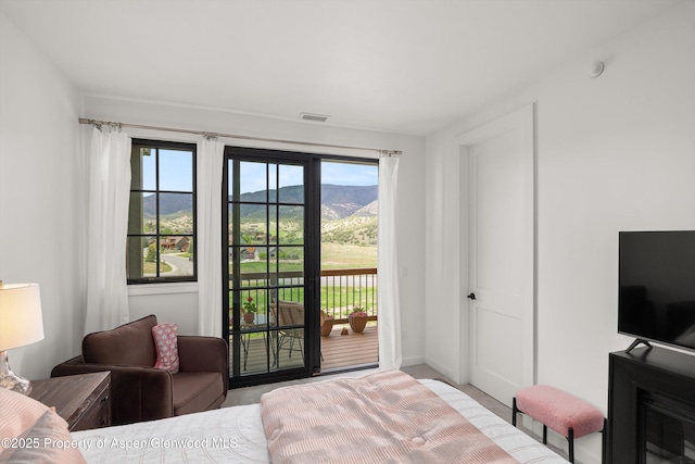 carpeted bedroom with access to exterior and baseboards