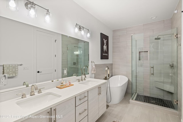 full bath with a shower stall, a freestanding tub, double vanity, tile patterned flooring, and tile walls