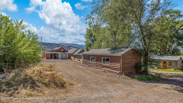 view of front of property with a mountain view and an outbuilding