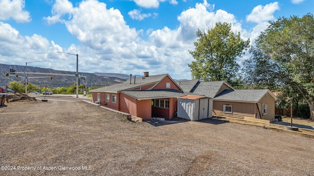 view of front of home featuring a mountain view and a storage unit