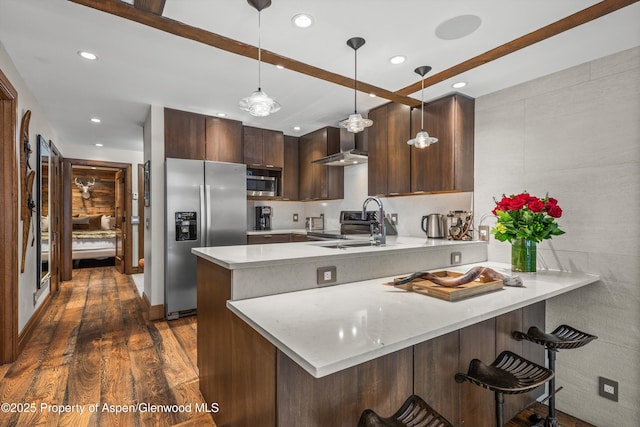 610 S W End St Unit K102, Aspen, CO 81611 - kitchen with appliances with stainless steel finishes, a sink, wall chimney range hood, a peninsula, and light countertops