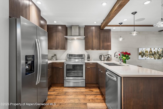 610 S W End St Unit K102, Aspen, CO 81611 - kitchen featuring stainless steel appliances, wall chimney range hood, a sink, dark wood-style flooring, and light countertops
