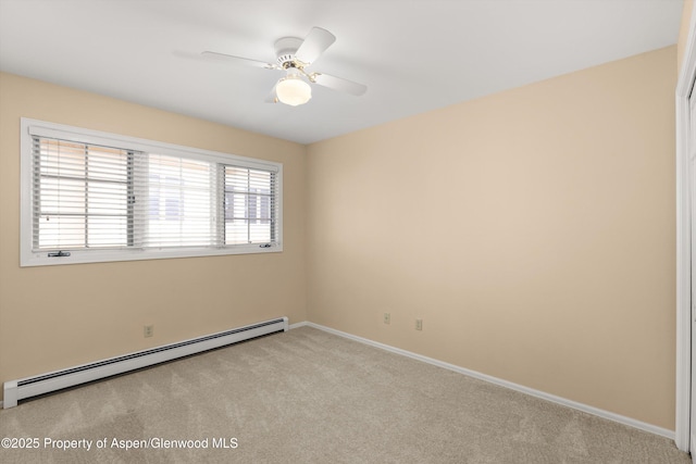 spare room featuring a baseboard heating unit, baseboards, light colored carpet, and a ceiling fan