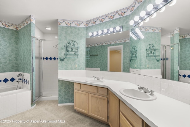 full bathroom featuring a sink, a stall shower, and wallpapered walls