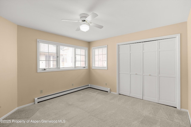 unfurnished bedroom featuring a baseboard radiator, baseboards, carpet, and a closet