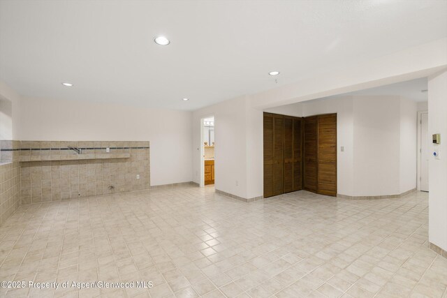 unfurnished living room with recessed lighting and baseboards