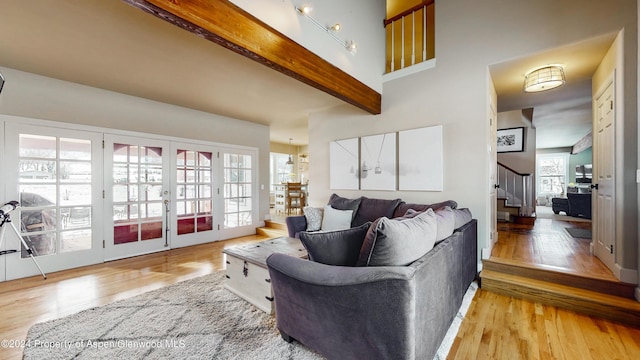 living room with light wood-type flooring, beam ceiling, stairway, and french doors