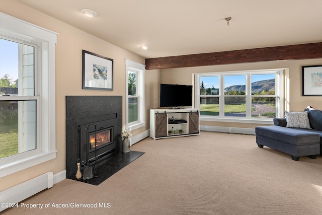 living area with baseboards, a baseboard heating unit, a high end fireplace, and light colored carpet