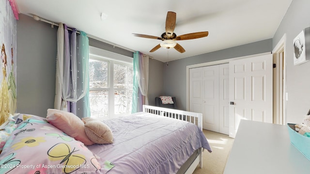 bedroom featuring a closet, light carpet, and ceiling fan