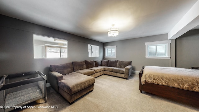 bedroom featuring light colored carpet and multiple windows