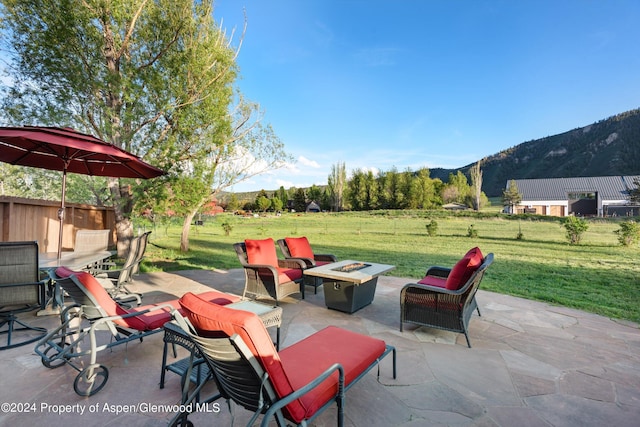 view of patio / terrace with an outdoor fire pit, a mountain view, and fence