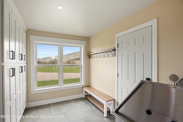 mudroom featuring a mountain view, baseboards, and light tile patterned floors