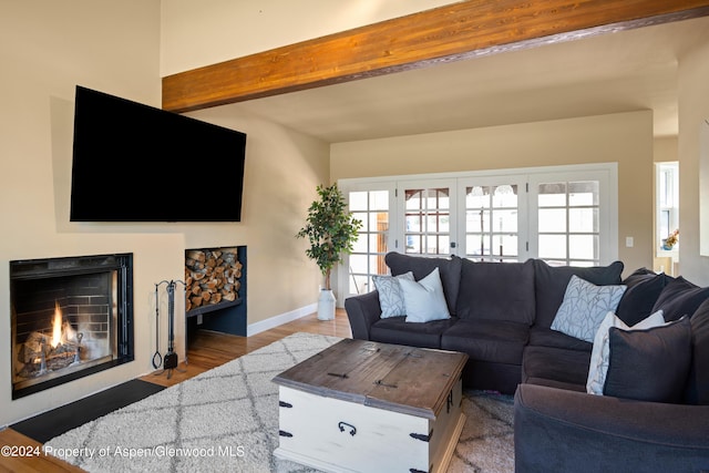 living room featuring a fireplace with flush hearth, a wealth of natural light, french doors, and beamed ceiling