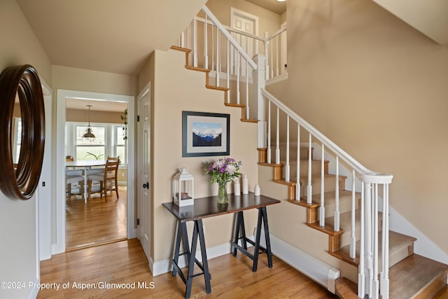 stairway featuring wood finished floors and baseboards