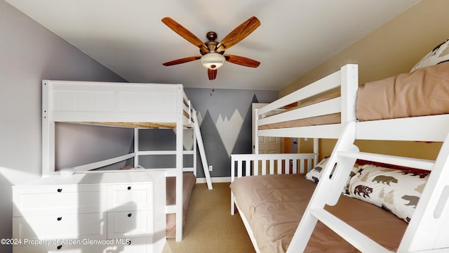 bedroom with carpet, baseboards, and vaulted ceiling