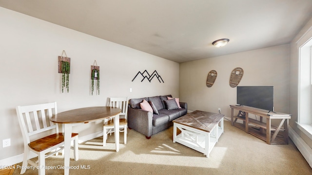 living room with baseboards and light colored carpet