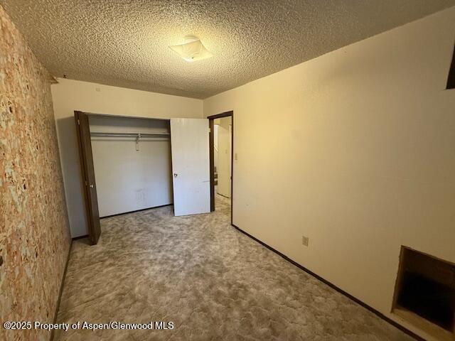 872 Russell St, Craig, CO 81625 - unfurnished bedroom featuring a closet, a textured ceiling, and carpet floors
