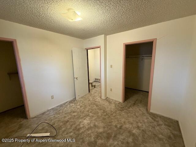 872 Russell St, Craig, CO 81625 - unfurnished bedroom featuring a closet, a spacious closet, carpet, and a textured ceiling