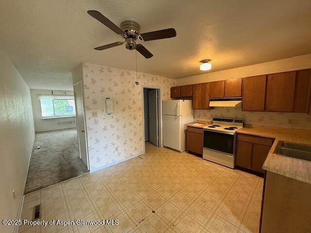872 Russell St, Craig, CO 81625 - kitchen with white appliances, under cabinet range hood, light countertops, a ceiling fan, and light floors