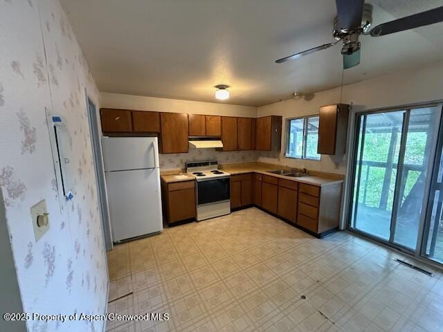 872 Russell St, Craig, CO 81625 - kitchen with white appliances, under cabinet range hood, light countertops, ceiling fan, and wallpapered walls