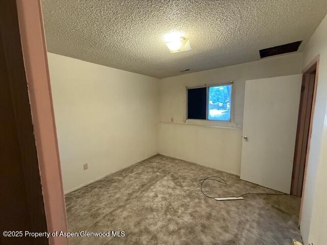 872 Russell St, Craig, CO 81625 - carpeted empty room with a textured ceiling