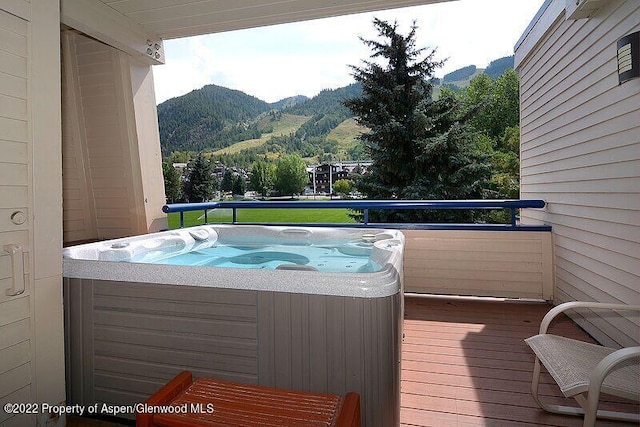 balcony with a mountain view and a hot tub