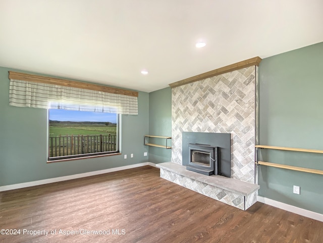 unfurnished living room featuring hardwood / wood-style floors and a wood stove