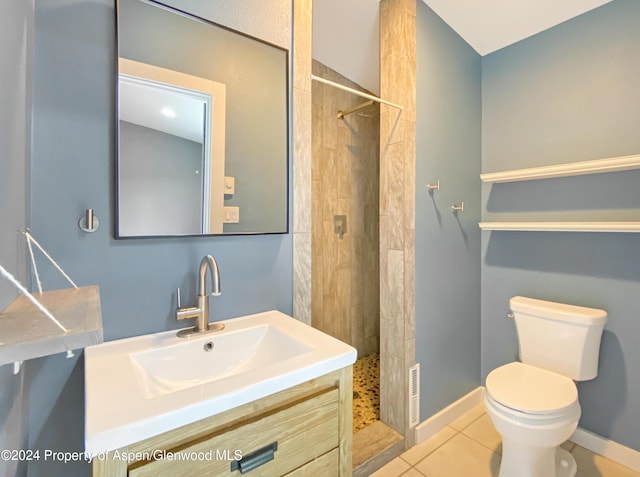 bathroom with tile patterned floors, toilet, vanity, and tiled shower