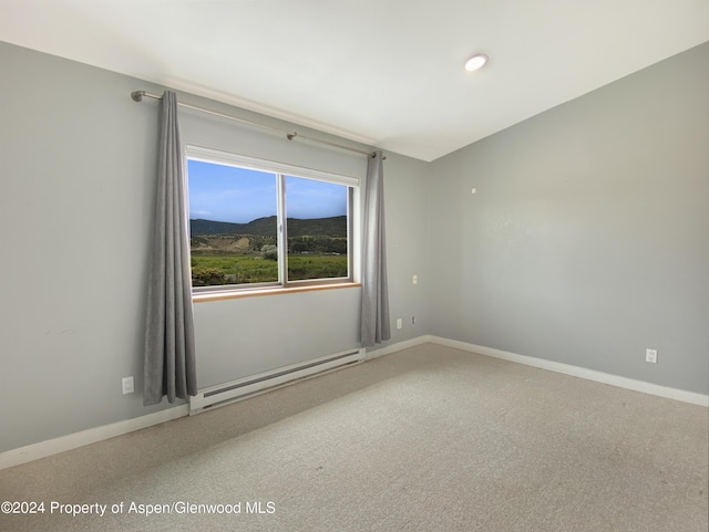 carpeted empty room with a mountain view and a baseboard radiator