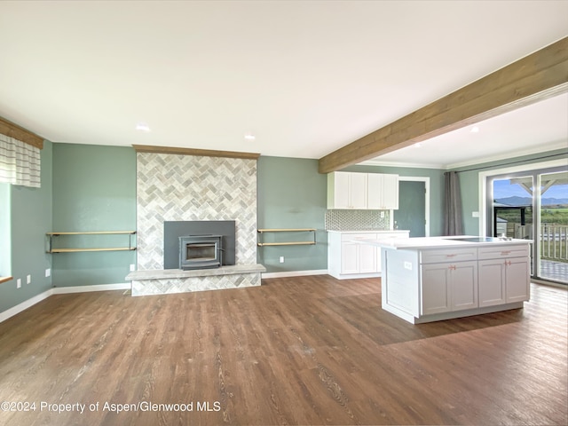 unfurnished living room with beam ceiling and dark wood-type flooring