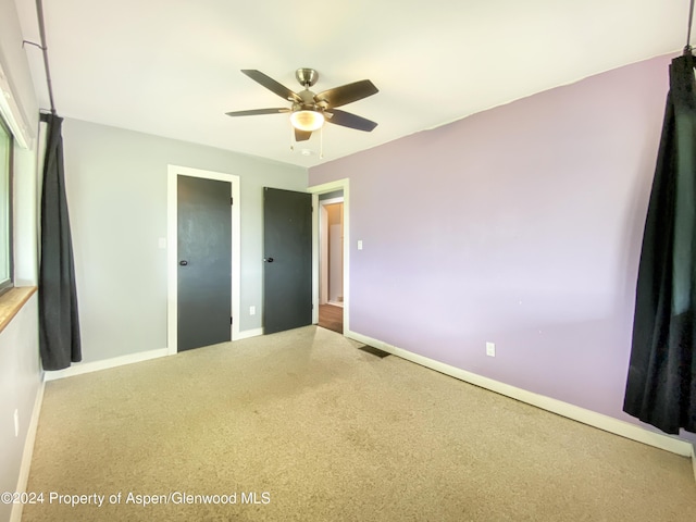 unfurnished bedroom featuring carpet and ceiling fan