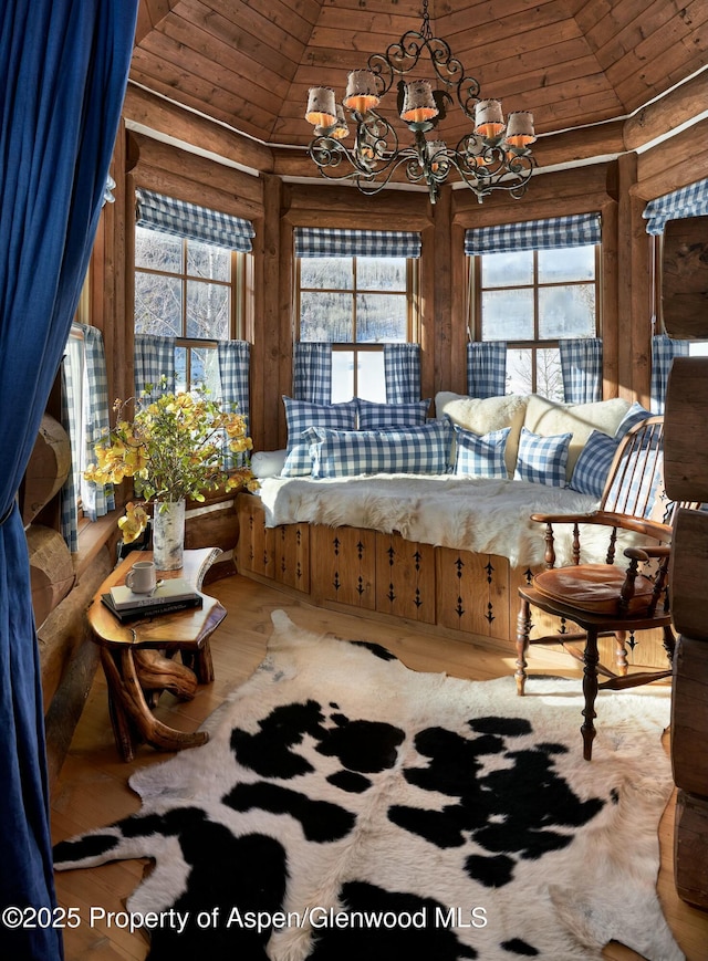 sunroom / solarium featuring an inviting chandelier, lofted ceiling, and wooden ceiling