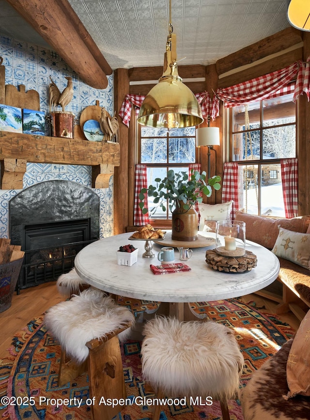 dining area featuring wood-type flooring and beam ceiling