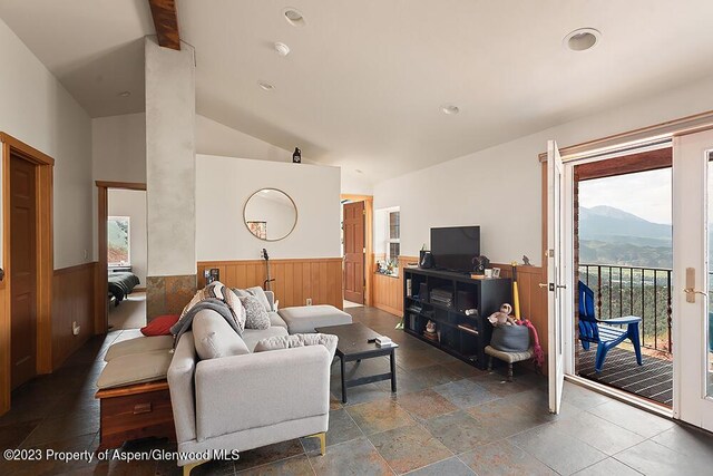 2800 Cedar Dr, Basalt, CO 81621 - living area featuring a wainscoted wall, lofted ceiling, wooden walls, and stone tile flooring