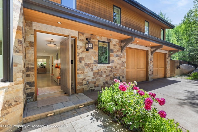 10 Ute Pl, Aspen, CO 81611 - view of exterior entry featuring stone siding, an attached garage, and driveway