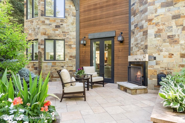 10 Ute Pl, Aspen, CO 81611 - view of patio featuring an outdoor stone fireplace and french doors