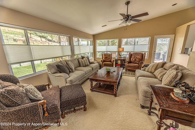 carpeted living room with lofted ceiling, plenty of natural light, and ceiling fan