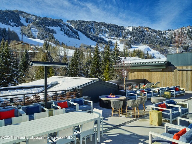 550 S Spring St Unit F8-10, Aspen, CO 81611 - snow covered patio featuring a fire pit, a mountain view, a patio, and outdoor dining space