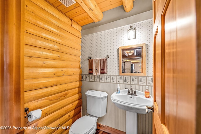 3 Hazel Lake Dr, Cimarron, CO 81220 - bathroom with wallpapered walls, toilet, wood ceiling with exposed beams, and wainscoting
